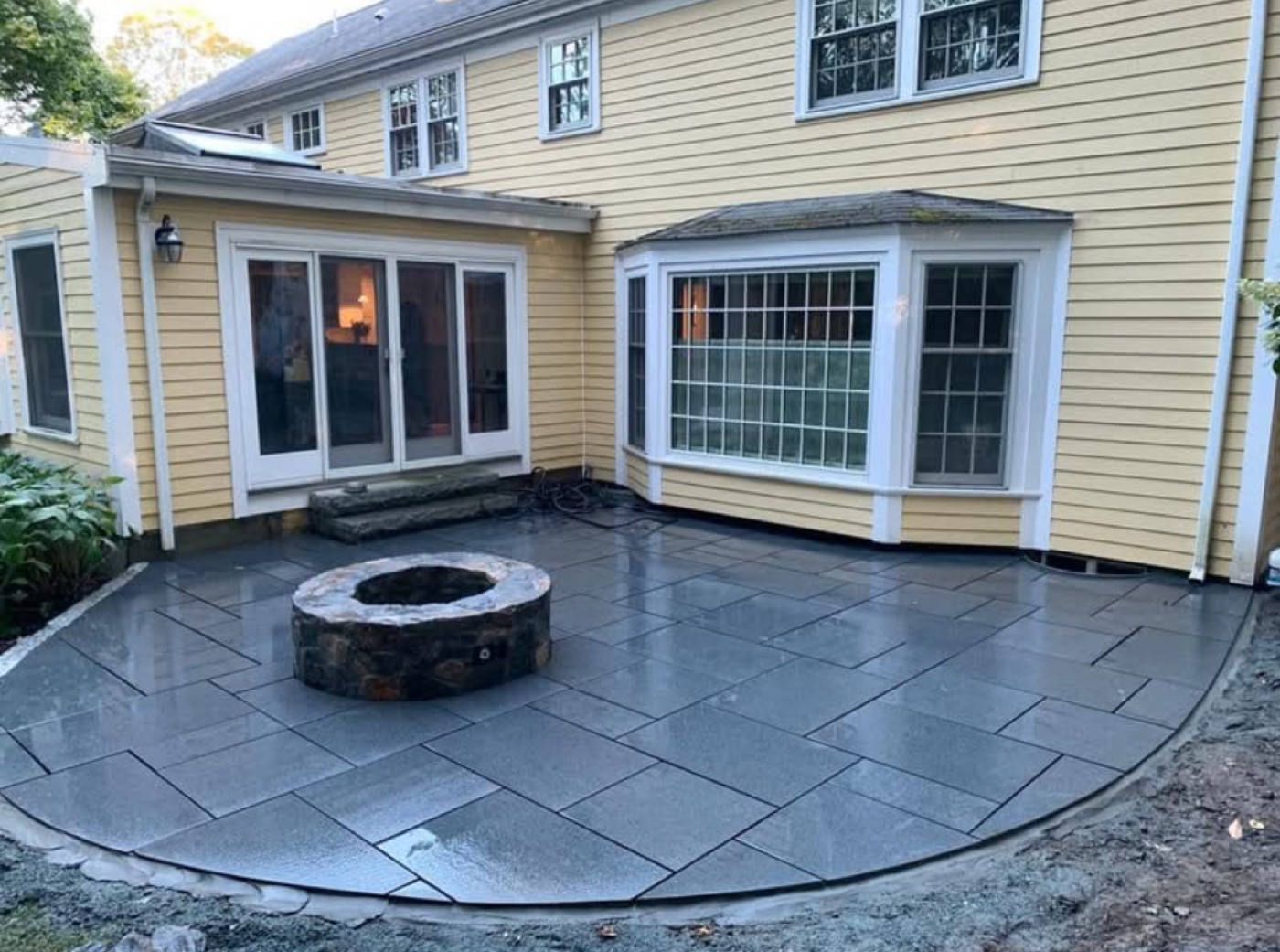 Bluestone patio with a round stone fire pit