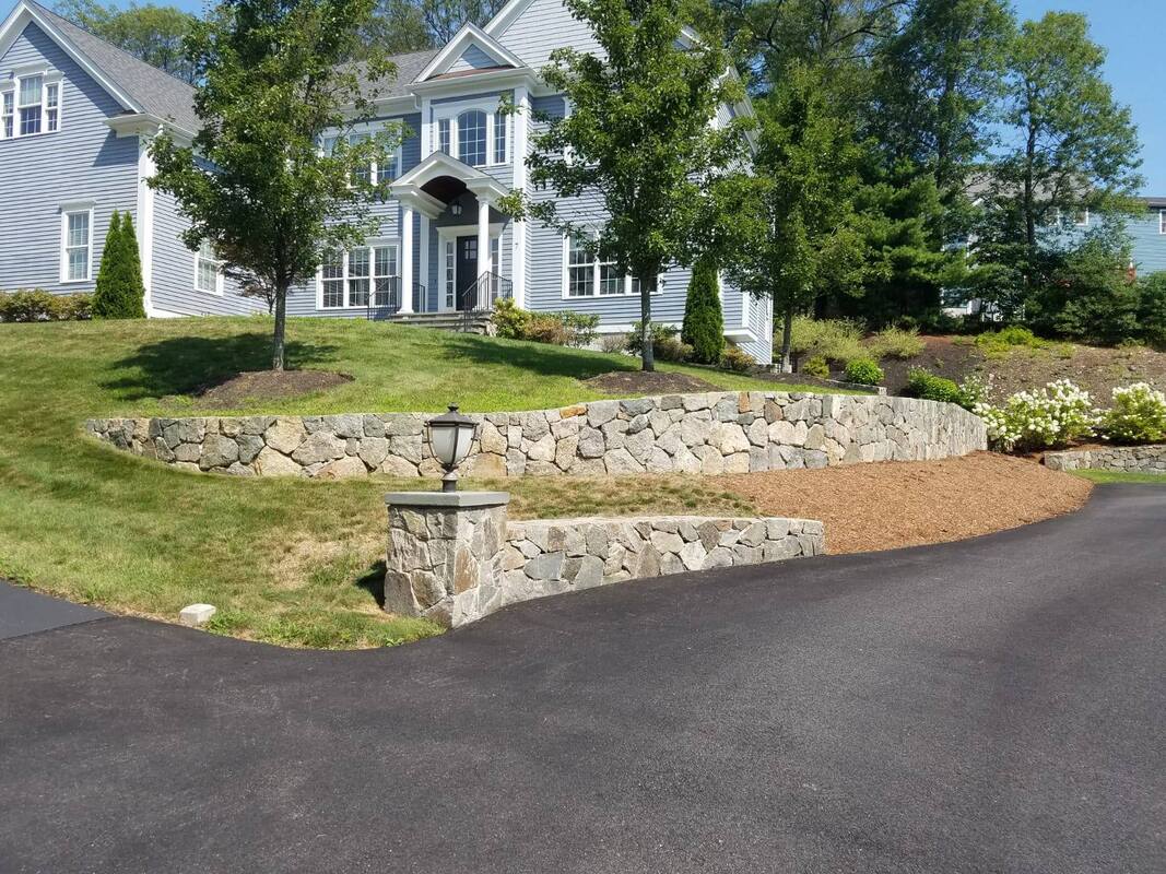 Curved fieldstone walls along a driveway