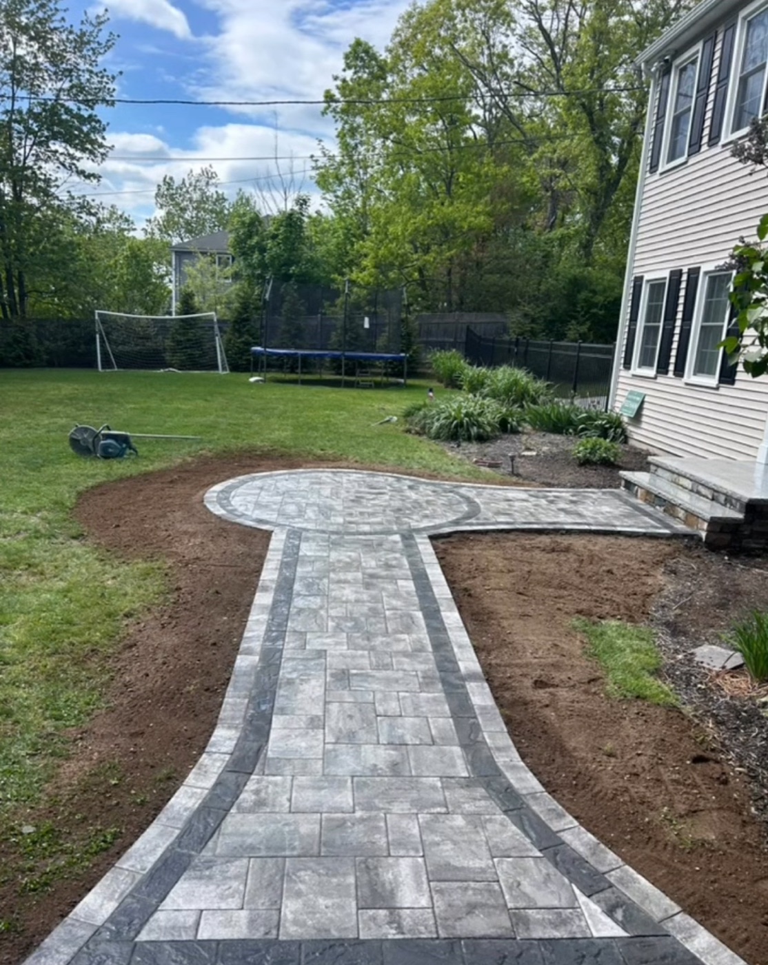 Paver walkway leading to a round landing